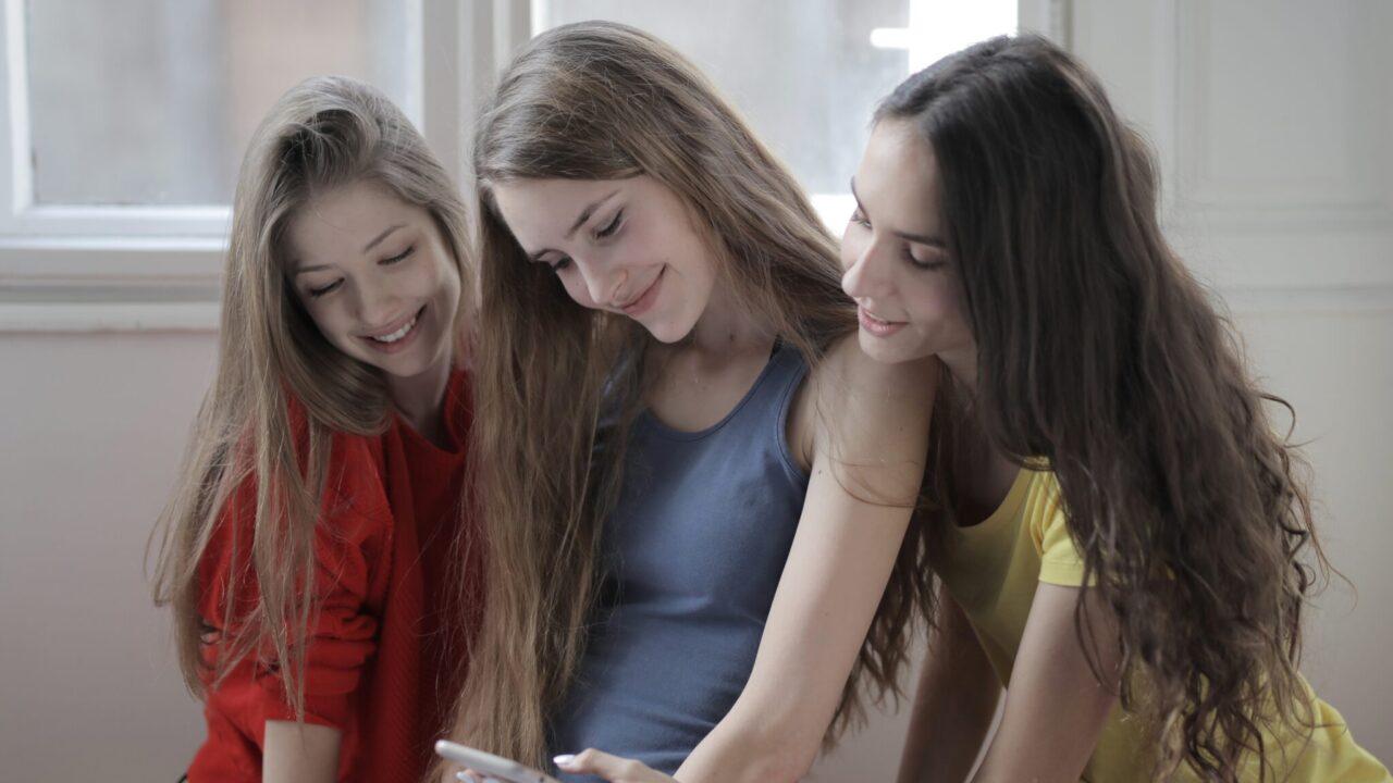 Nuoret naiset katsovat kännykästä Tiktok-videoita.