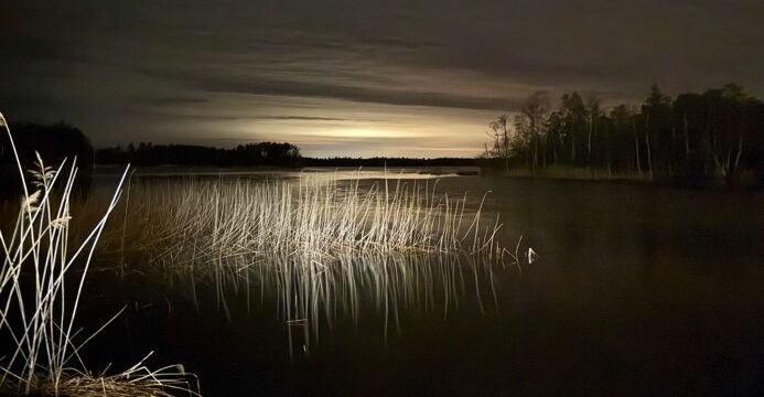 The lake water with a streak of sunlight behind an island
