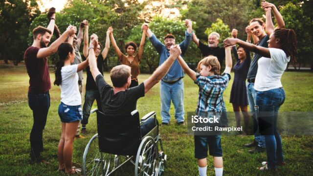 People of different abilities holding hands in a circle