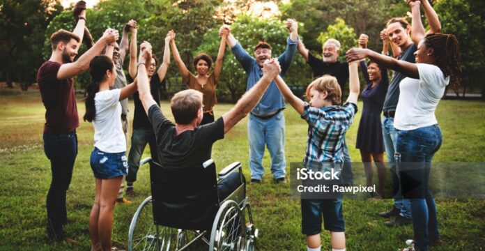 People of different abilities holding hands in a circle