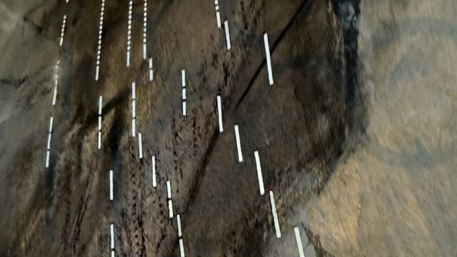 Close up of light coming through pianola scroll holes, looking very digital and mysterious